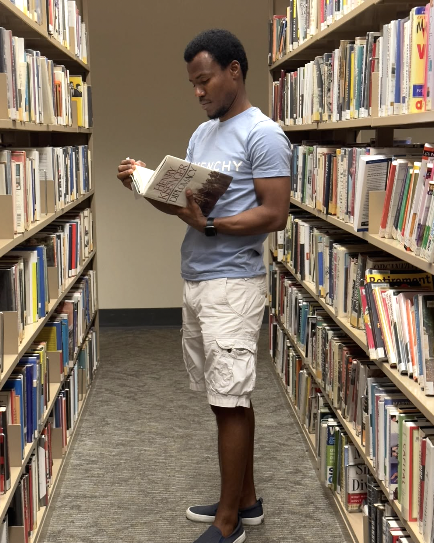 Junior Ceranor Nelson reading Kissinger's Diplomacy at Malden Public Library